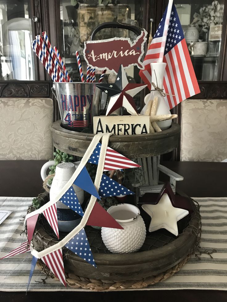 Classic 4th of July dining table tray with flags, stars, bunting, mason jars, and wood signs saying 'America.'