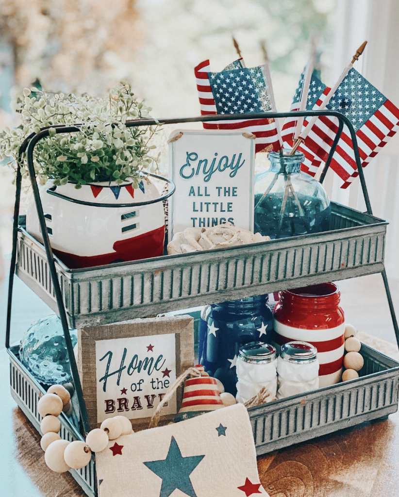 Calm and cheerful tray in a metal caddy with soft greenery, mason jars, flags, wooden beads, and uplifting signs.