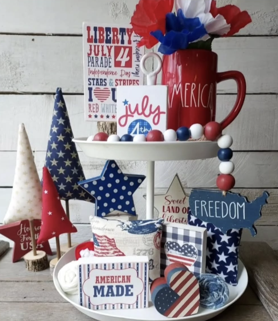 Colourful patriotic tray filled with bold signs, striped stars, heart shapes, fabric trees, and paper flowers.