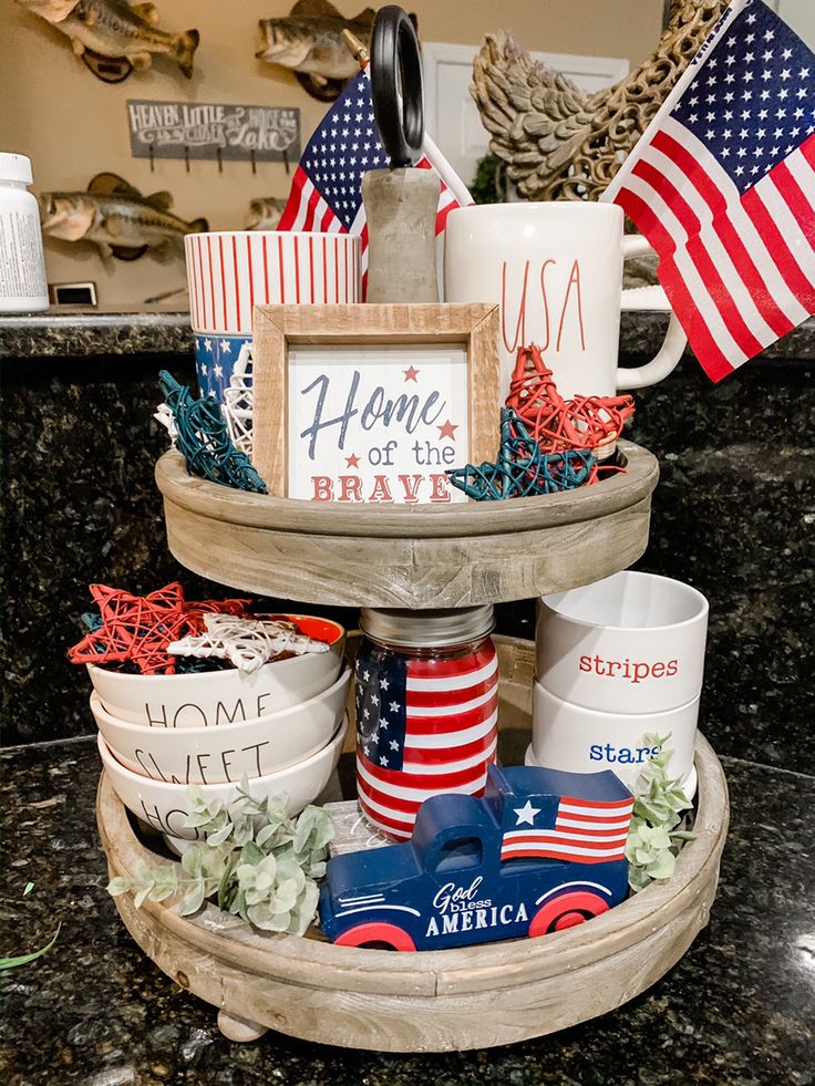 Full and festive three-tiered tray wrapped in ribbons, with 'Home of a Soldier' sign, USA mugs, and lots of patriotic decor.
