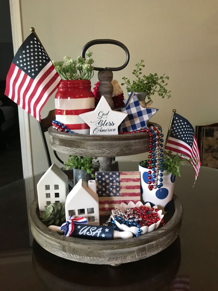 Rustic Americana tray with ceramic houses, flag art, bold mugs, and a mix of beaded garland and star decor.