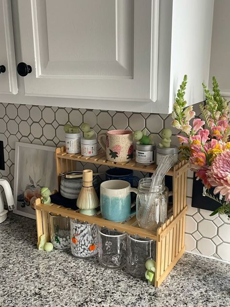 Cottage-style matcha bar with bamboo shelf, fresh flowers, matcha mugs, and small decorative frogs
