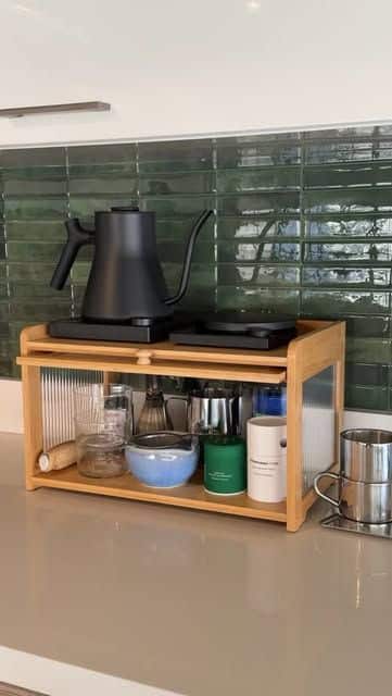 Sleek and modern matcha station with black kettle, frother, matcha tins, and hidden storage shelf.