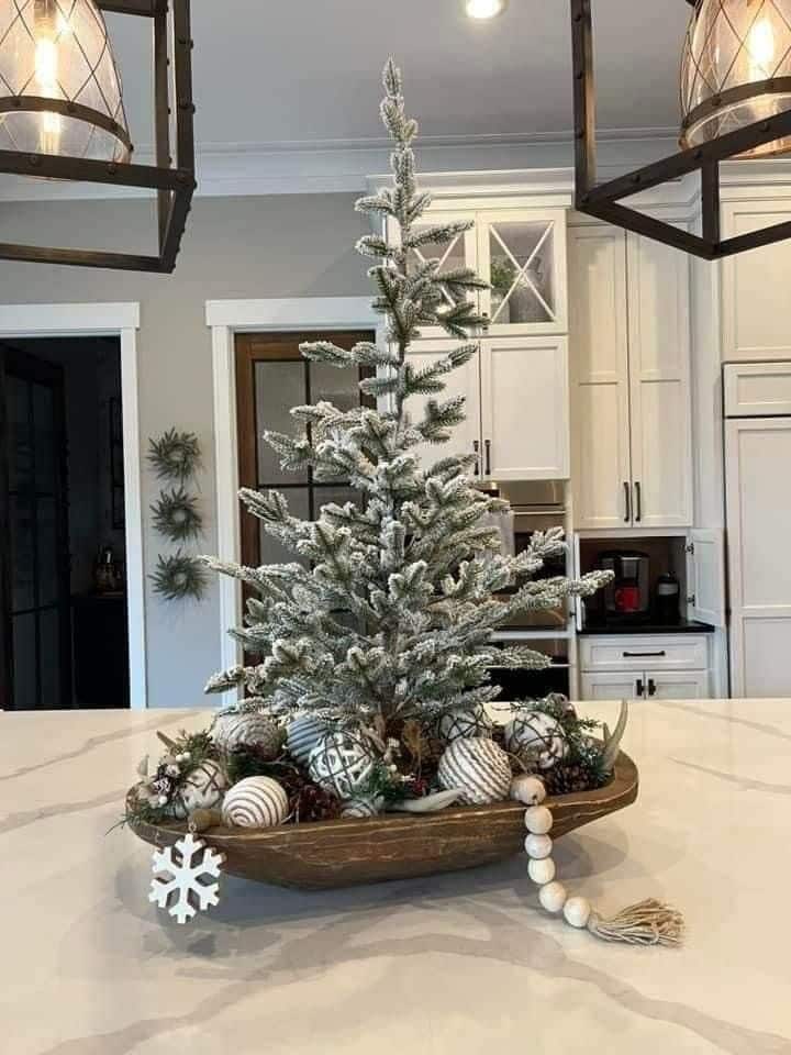 Flocked Christmas tree dough bowl centerpiece with white and wood ornaments and wooden beads.
