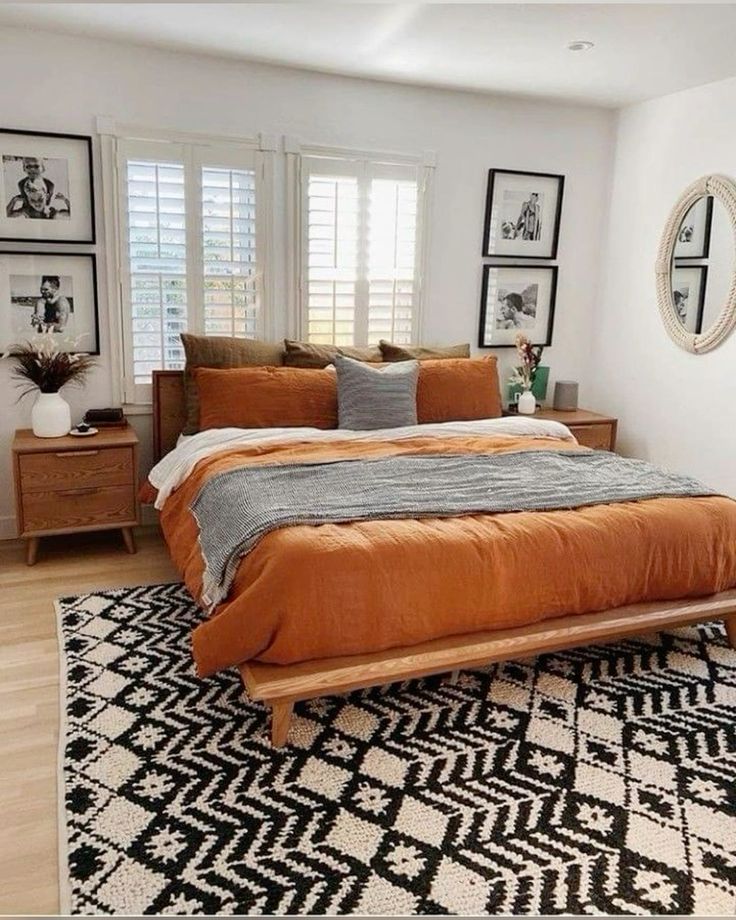 Boho bedroom with burnt orange linen bedding and a bold black and white geometric rug