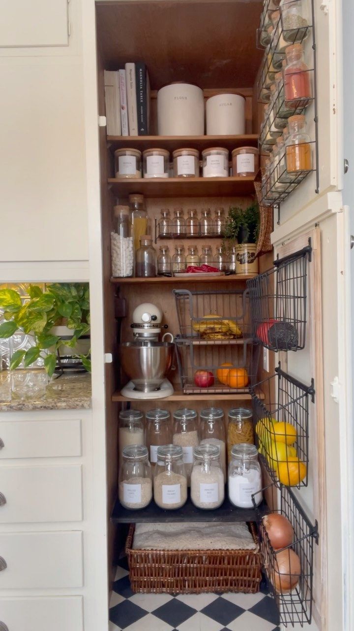 Pantry closet with hanging wire baskets storing fruit and vegetables on the door
