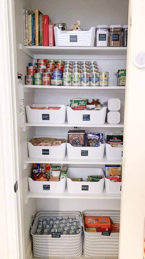 Narrow closet pantry with labeled white totes organizing snacks and pantry items