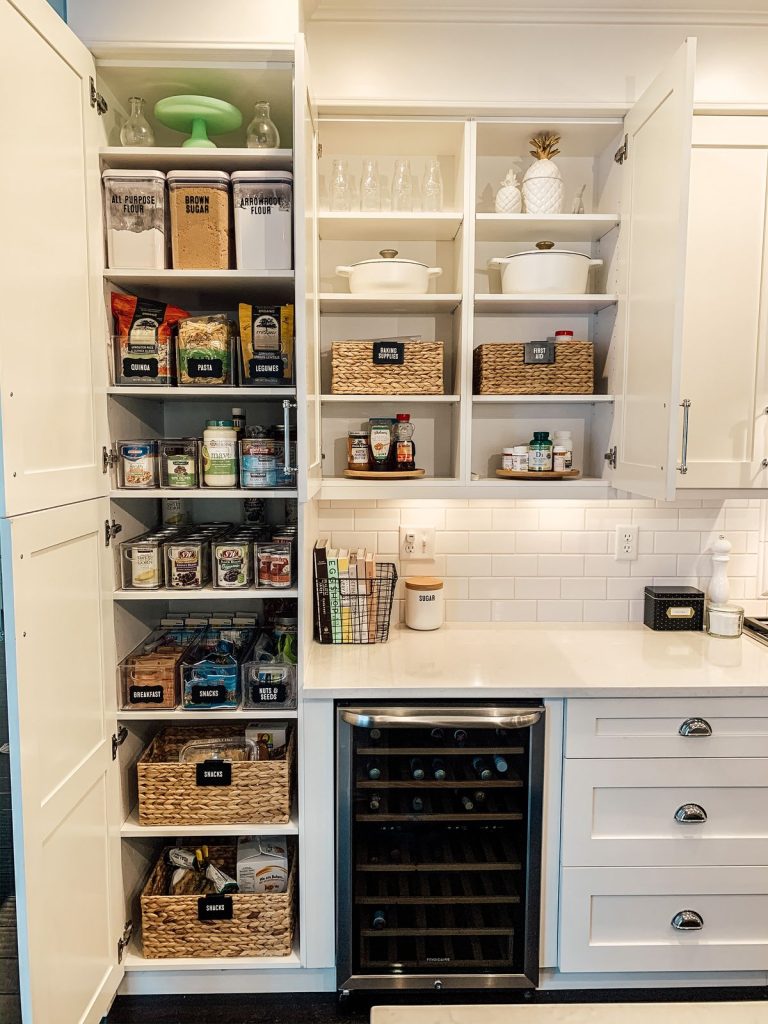 Pantry shelves and overhead cabinets organized together with labeled bins and baskets