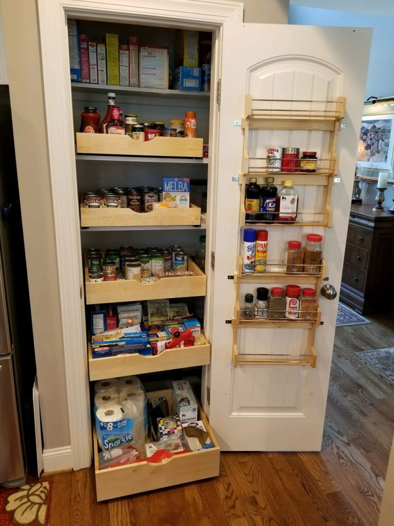 Pantry closet with pull out wood drawers and a door mounted spice rack
