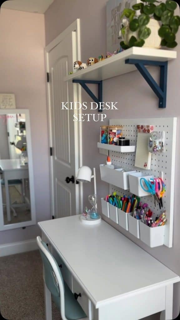 Kids desk setup with pegboard organizer above a white wall mounted desk