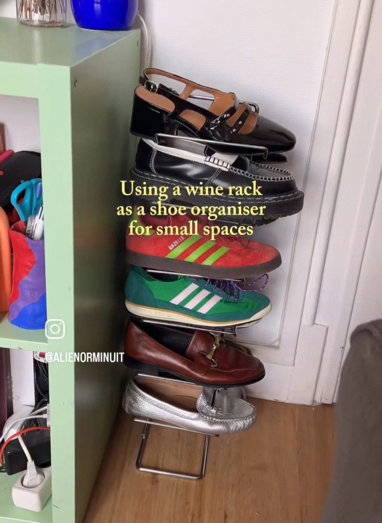 Metal wine rack used as a shoe stand, holding loafers, sneakers, and mary janes in each slot beside a green shelving unit.