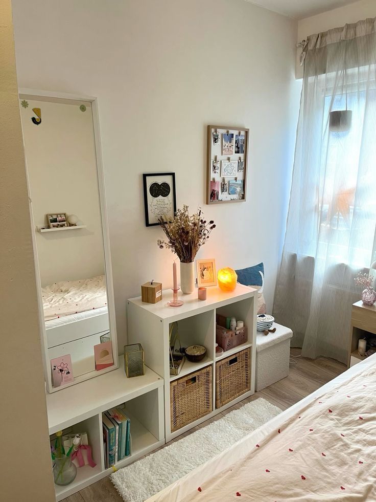 White cube storage with wicker baskets sits beneath a full length mirror and a small salt lamp on top.
Cube storage wor