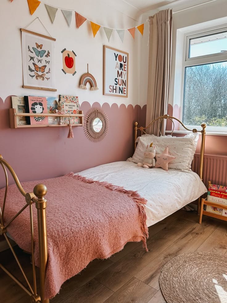 Pink kids bedroom with gallery wall and vintage brass bed