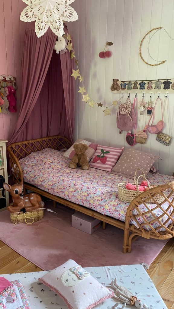 Kids bedroom with pink canopy over a rattan daybed